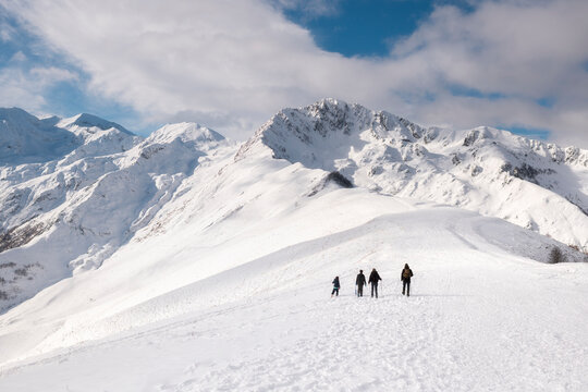 Family Hiking Towards Snowy Mountain Summit