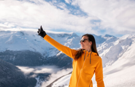 Smiling Woman Taking a Selfie on a Snow mountain