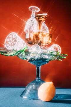 Glassware and lemon on a table against a red background
