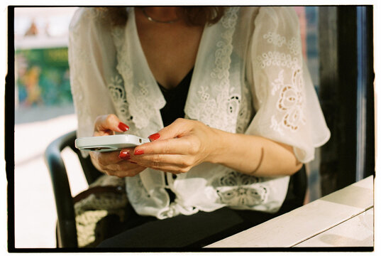 Anonymous woman using smartphone at outdoor cafe