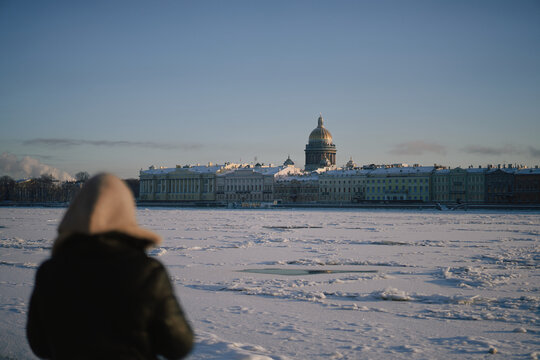 Young Woman In Winter Coat And Hood Warming Hands Outdoors 