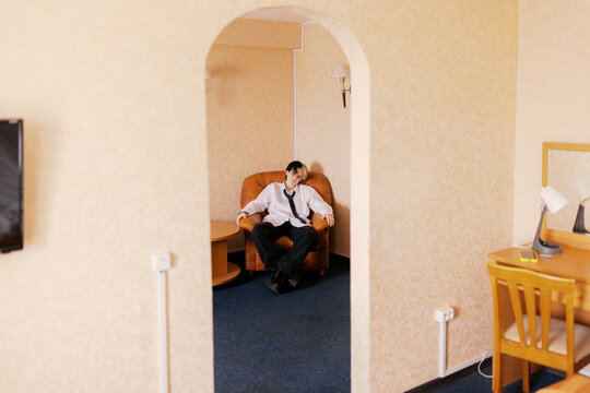 Person Sits in Chair Inside a Simple Room With Light Walls