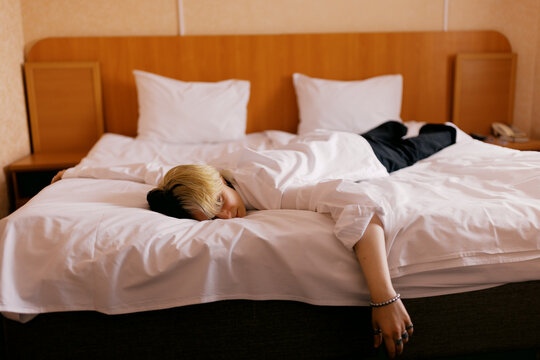 Person Lying on Bed in Hotel Room During Daytime