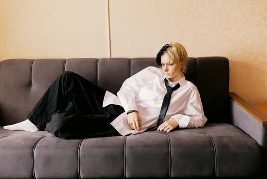 Youth Rests on Couch in an Indoor Setting During Daytime