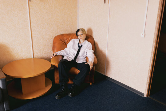 Person Sitting in a Chair in a Room With Simple Decor
