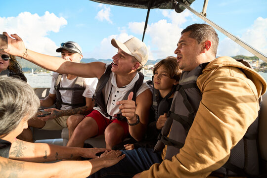 Group of people enjoying boat trip wearing life jackets