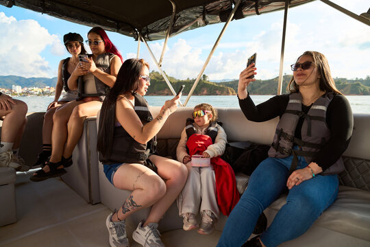People boating on lake taking smartphone selfies