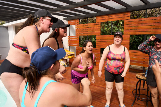 Women friends enjoying singing together at pool party