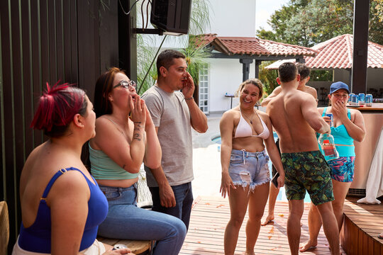 Diverse friends laughing at fun poolside party