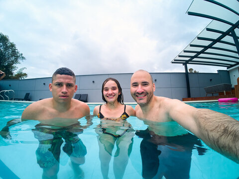 Friends enjoying summer vacation with a pool selfie