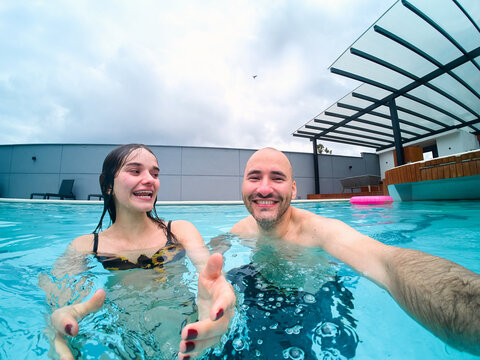 Happy couple enjoying fun selfie in swimming pool