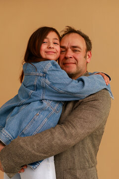 Father and Daughter Share a Hug in a Simple Studio Setting