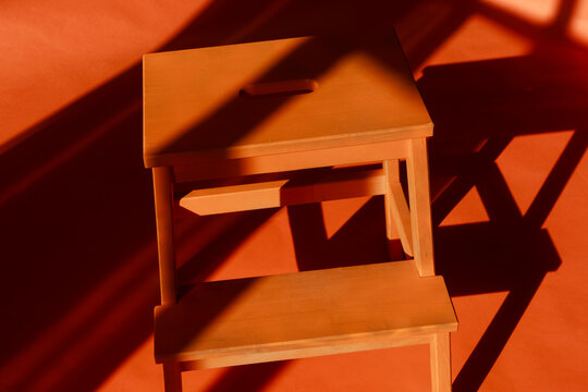 Wooden Chair Under Soft Light on a Red Floor in a Room