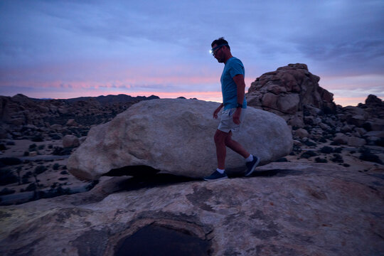 Man Walks During Twilight in Desert Landscape