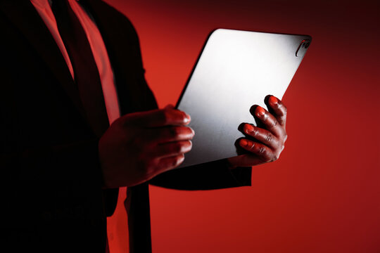 Businessman Holding Tablet With Dramatic Red Lighting