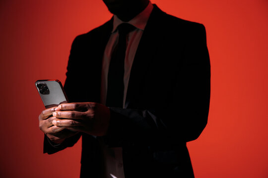 Businessman Using Smartphone In Dramatic Red Light