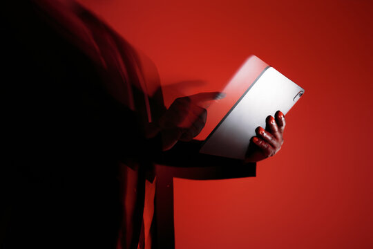 Businessman Using Tablet Touchscreen With Red Lighting