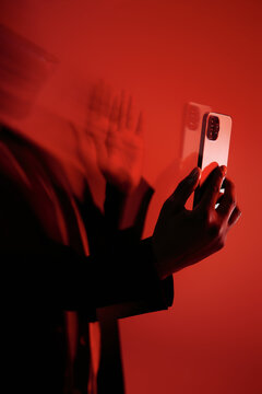Person Holding Smartphone With Red Motion Blur