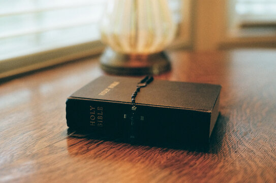 Wide shot of Rosary Beads with Crucifix on Table Leaving Room for Copy