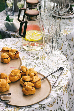 Profiteroles with meat filling and cream cheese on plates at table.