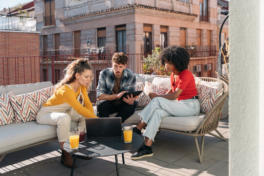 Young adults coworking on panoramic rooftop terrace