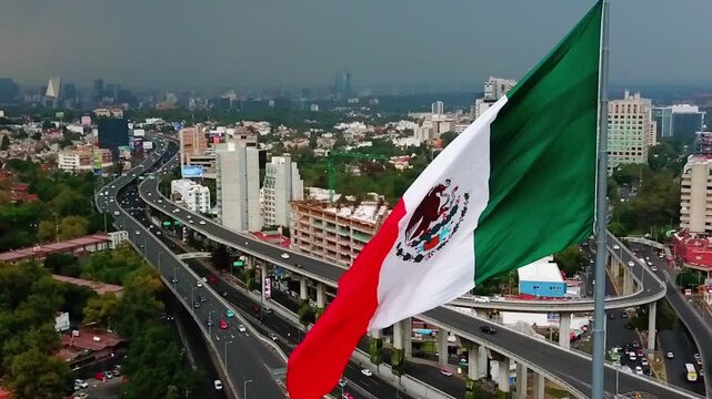 Mexican flag waving in Mexico City, a cosmopolitan city full of buildings, plazas, streets and avenues