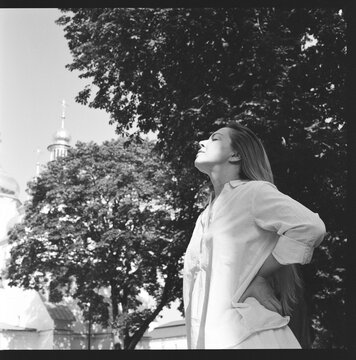 Woman Standing in Sunlight Beneath Trees