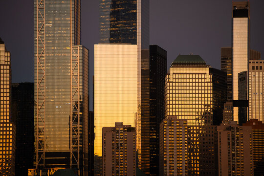New York City skyline with golden sunset reflections on skyscrapers
