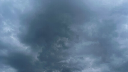 Fototapeta premium The dark sky with heavy clouds converging and a violent storm before the rain.Bad or moody weather sky and environment. carbon dioxide emissions, greenhouse effect, global warming, climate change.