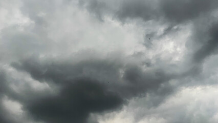 Fototapeta premium The dark sky with heavy clouds converging and a violent storm before the rain.Bad or moody weather sky and environment. carbon dioxide emissions, greenhouse effect, global warming, climate change.