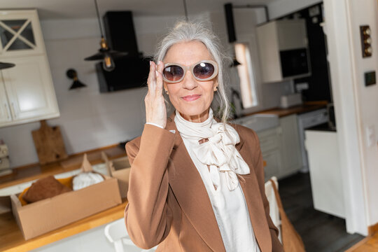 Senior woman trying sunglasses at home