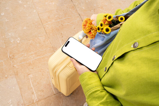 Luggage, flowers, and phone during travel in a vibrant setting
