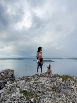 Woman and Dog Standing on a Scenic Rock River View