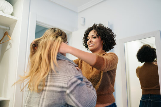 People helping each other with personal styling at home