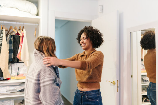 Friends finding clothing items, enjoying fashion and style