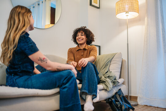 Friends sharing conversation and laughter on sofa