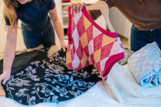 Friends organizing clothes during a closet decluttering session