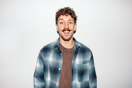 Young man smiling with curly hair and mustache