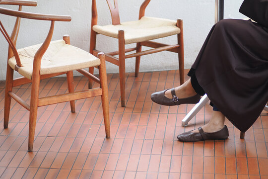 Sitting quietly with two wooden chairs nearby