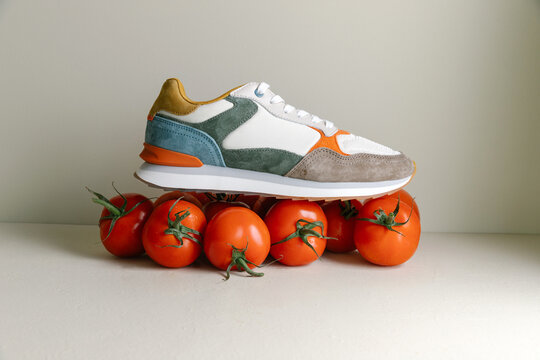 Still life of colourful sneakers and tomatoes
