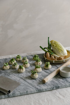 Adorable handmade cabbage dumplings on marble slab