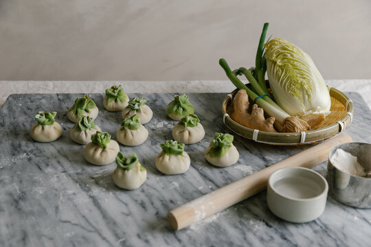 Adorable handmade cabbage dumplings on marble slab