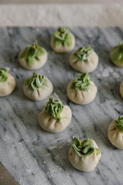 Adorable handmade cabbage dumplings on marble slab