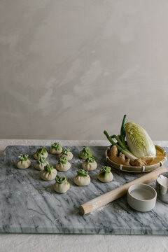 Adorable handmade cabbage dumplings on marble slab