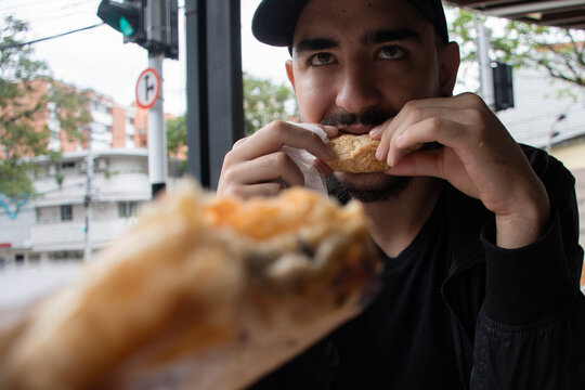 Man Enjoys Baked Goods and Drink at a Cafe in the Afternoon