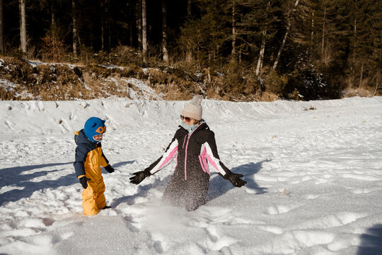 A toddler and his mom are having fun together in winter