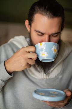 Portrait of man drinking tea from flower cup