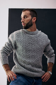 Man Posing in Casual Sweater Against Black Backdrop