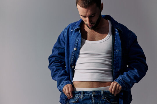 Man Wears Denim Jacket and White Tank Top in Studio Setting