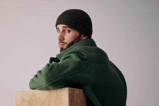 Man Poses With Wooden Block in Studio During Fashion Shoot